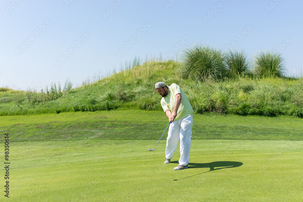 Successful man playing golf at club