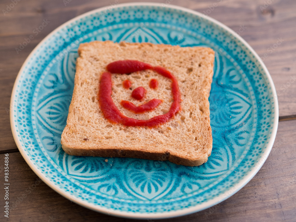 Toast mit einem fröhlichen Ketchup-Gesicht Stock Photo | Adobe Stock