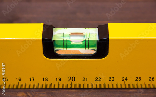 Carpenter's level on wooden table seen from very close