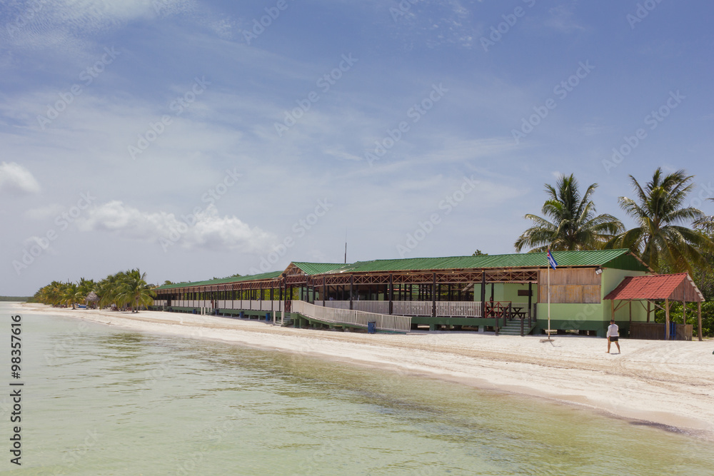 Beautiful beach with palm trees and traditional restaurant and blue sky Beautiful beach with palm trees and traditional restaurant and blue sky