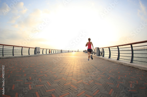  young fitness woman runner running at seaside