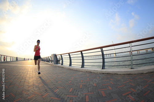  young fitness woman runner running at seaside