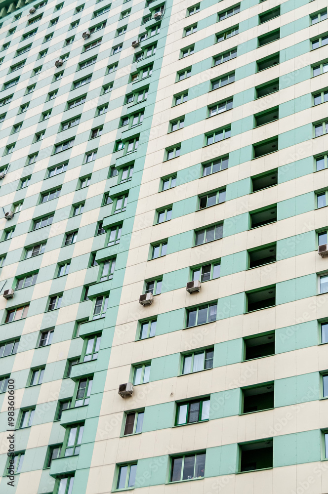 Multistoried building façade with air-conditioners on wall.
Multistoried building façade with air-conditioners on wall.