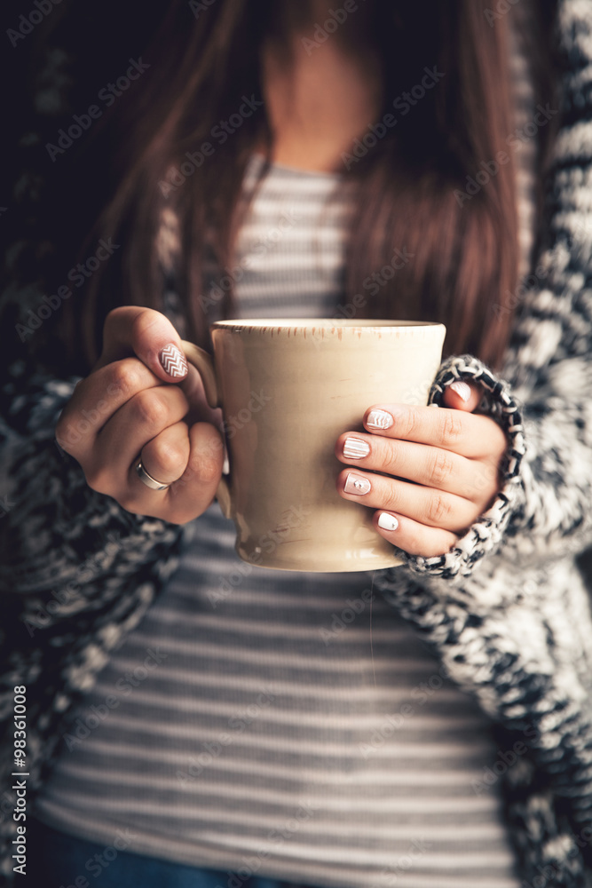 Girl's hands holding a cup of coffee Girl's hands holding a cup of coffee