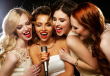 Four beautiful stylish girls singing karaoke 