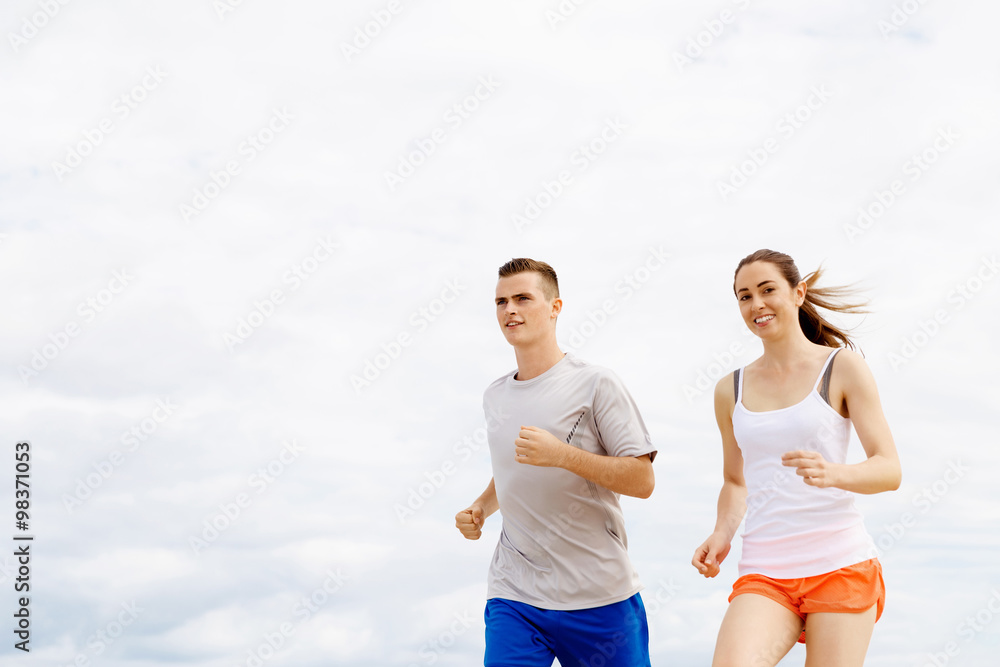 Runners. Young couple running on beach Runners. Young couple running on beach