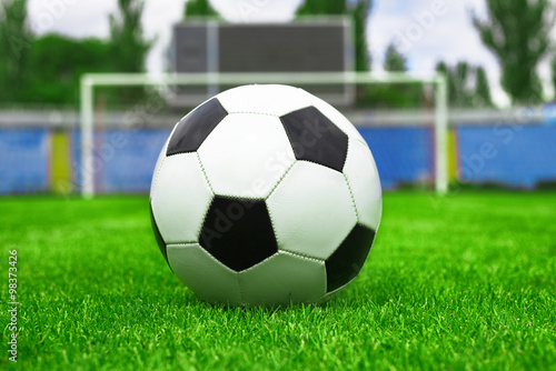 soccer ball on a green lawn on the background of the stadium