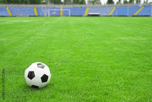 soccer ball on a green lawn on the background of the stadium © Studio KIVI
