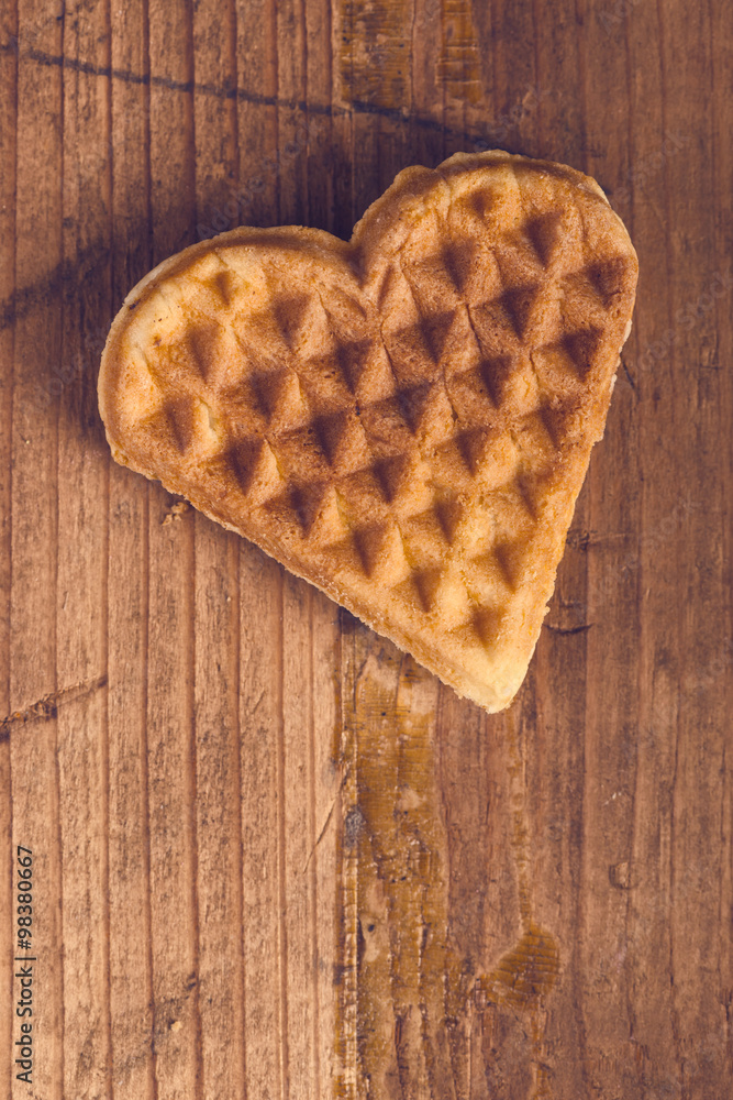Heart shaped homemade waffle on wooden desk Heart shaped homemade waffle on wooden desk