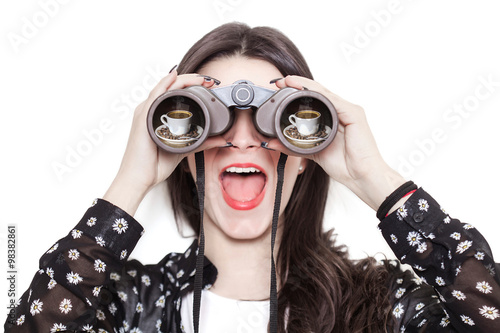 Girl portrait looking at coffee cup through binoculars