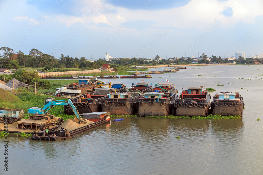 Fototapeta premium Backhoe load sand in Big barge