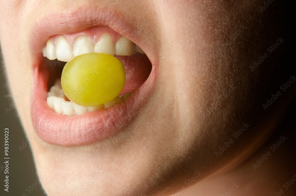 Naklejka premium Lips biting on grape