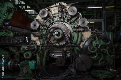 Old 1960s industrial cotton working machine in a dark factory atmosphere