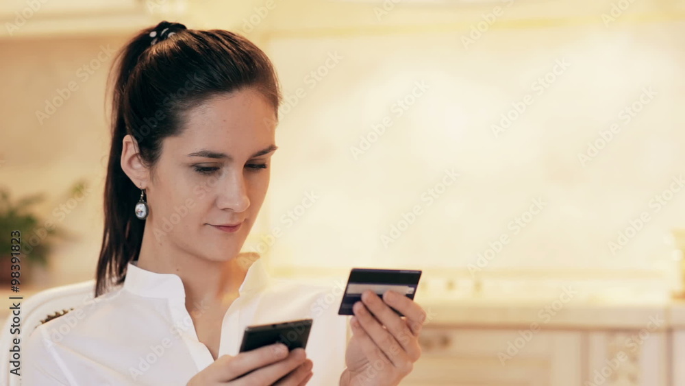 Woman shopping online with mobile phone at home Woman shopping online with mobile phone at home