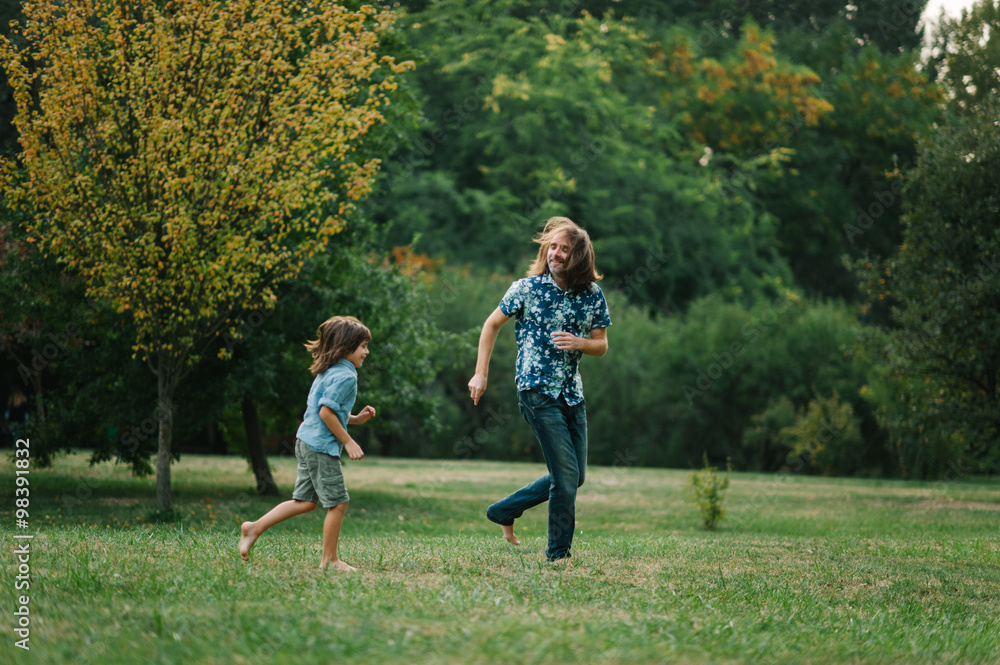 Fototapeta premium Happy young hipster family having fun while running, bowl, rising up, piggyback ride their children in park on summer sunset 