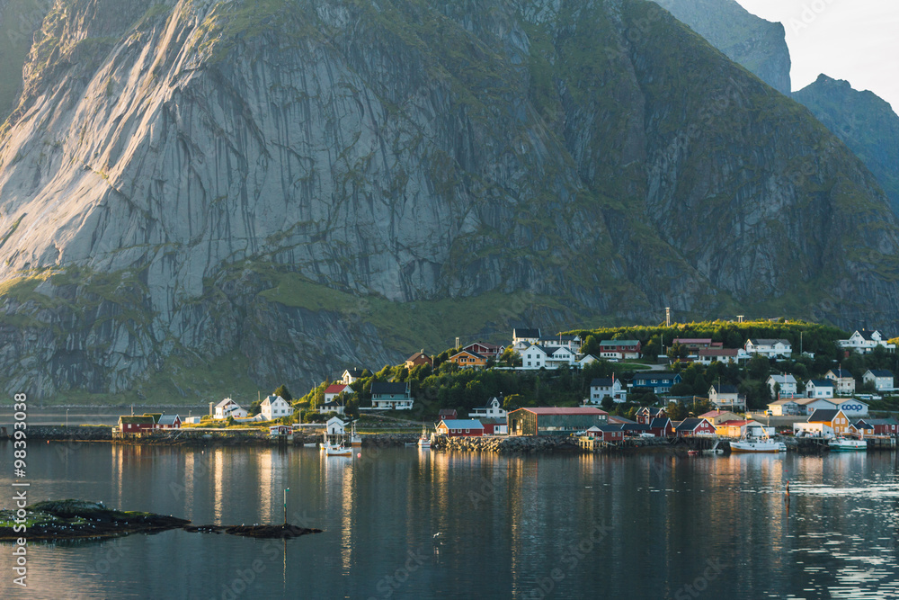 Small seaside town situated at the foot of a mountain in sunset light Norway