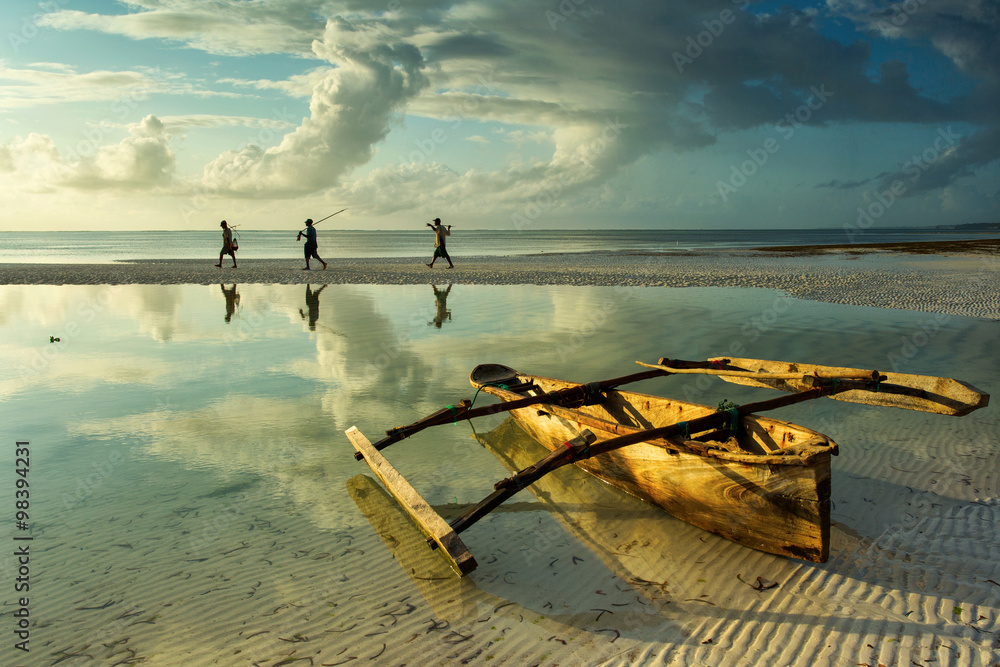 Traditional fisher boat in Zanzibar with people going to fish on - obrazy, fototapety, plakaty 