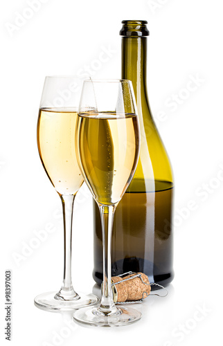 Two glasses of champagne on the background of brown bottles close-up isolated on a white. Festive still life.