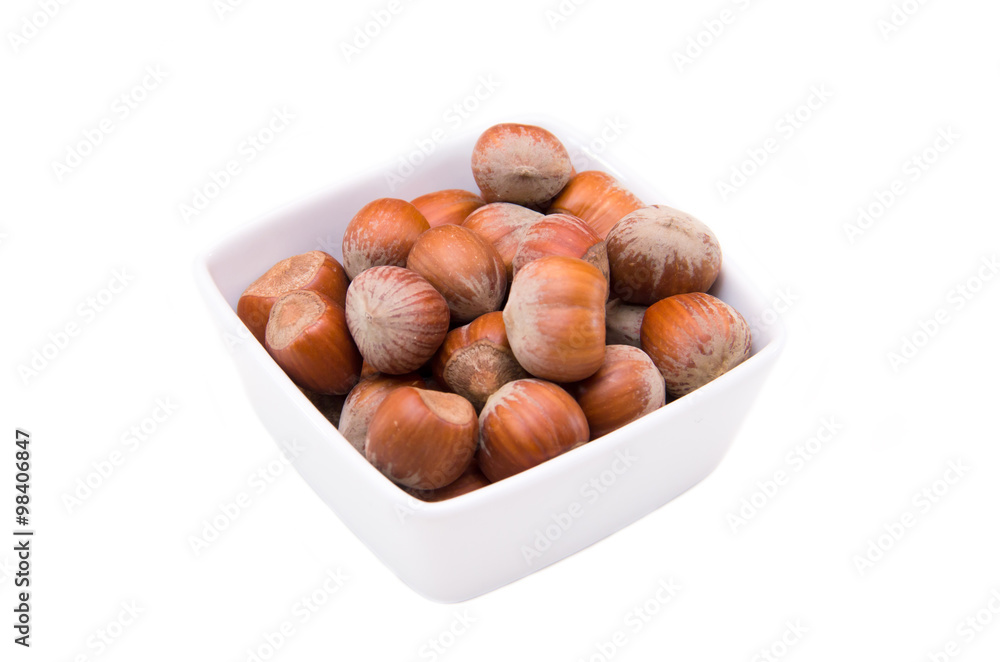 Hazelnuts on square bowl on a white background Hazelnuts on square bowl on a white background