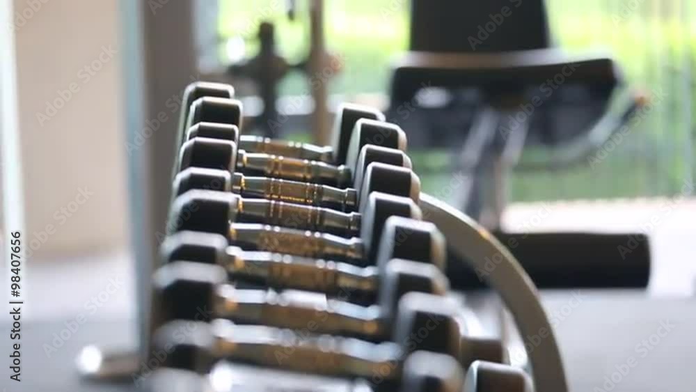 Sports dumbbells rubber in modern sports club. Weight Training Equipment. Camera in motion Sports dumbbells rubber in modern sports club. Weight Training Equipment. Camera in motion