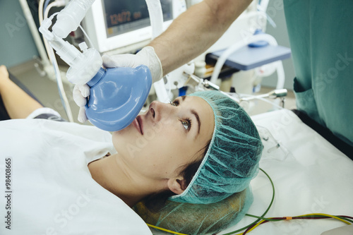 Patient on operating table being given an anesthetic mask