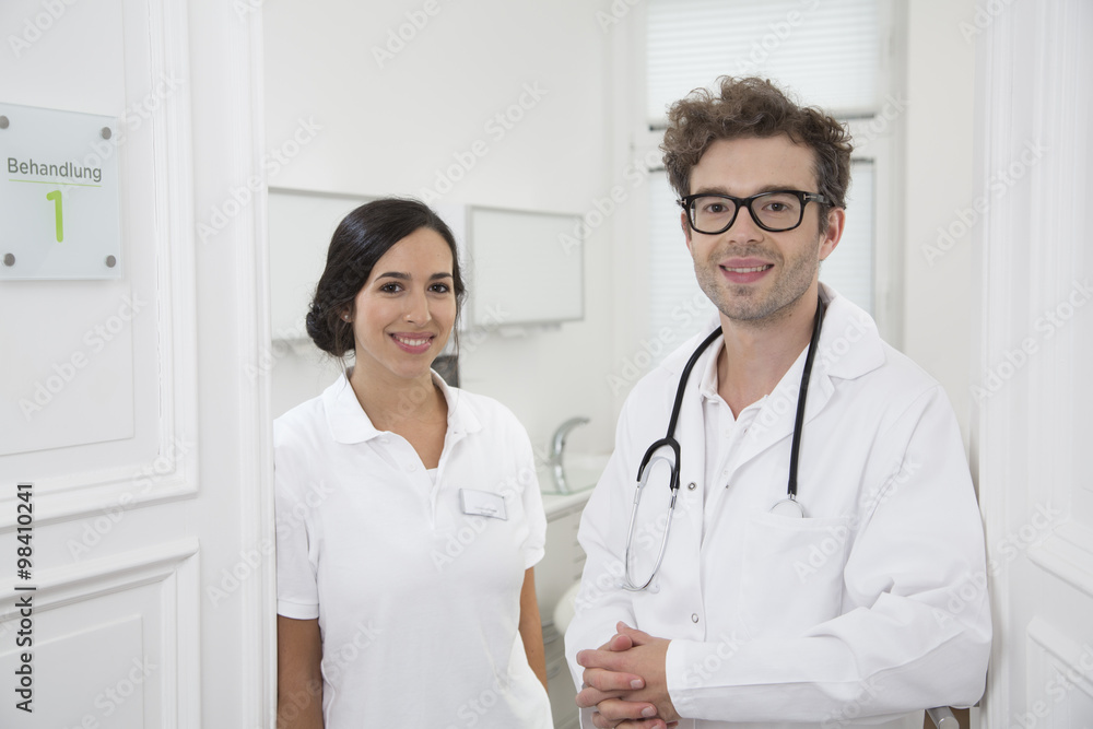 Portrait of smiling doctor and medical secretary at medical practice Portrait of smiling doctor and medical secretary at medical practice