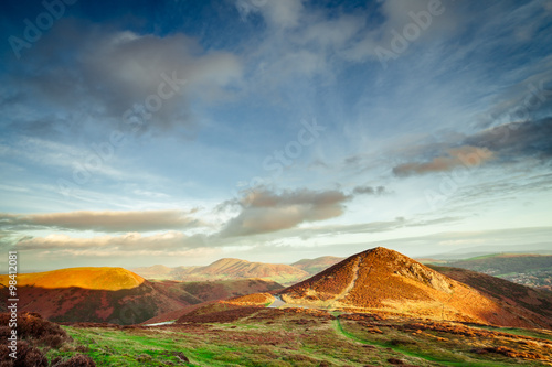 Autumnal Heather Hills Flooded in Warm  SunsetLight and Beautiful Clouds photo