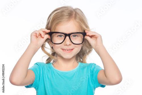Little girl trying on glasses.