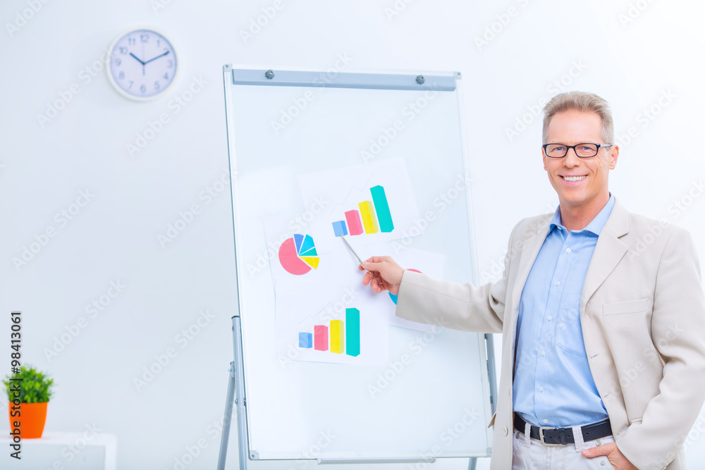 Smiling businessman working with charts. Smiling businessman working with charts.