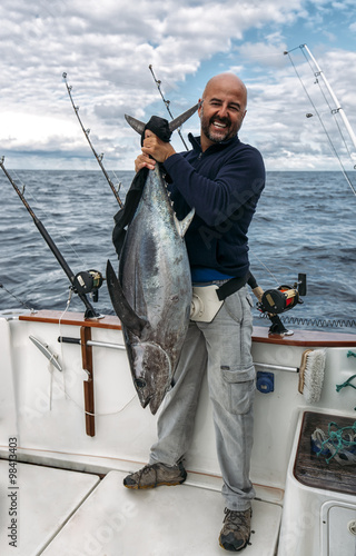 Spain, Asturias, Fisherman holding freshly caught tuna photo