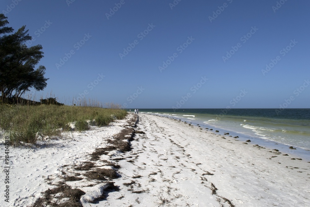 Wide tropical beach with white sand and person in background Wide tropical beach with white sand and person in background