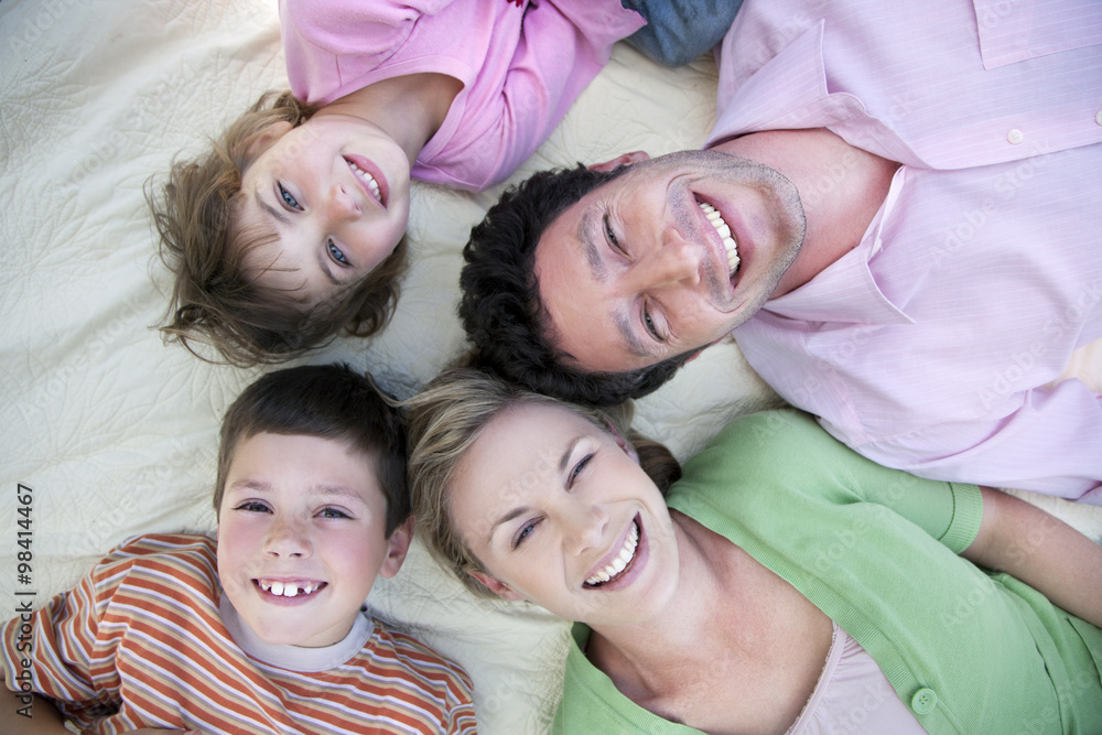 Group picture of happy family lying together on blanket Group picture of happy family lying together on blanket