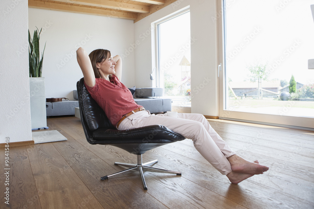 Mature woman sitting relaxed in her living room, drinking coffee Mature woman sitting relaxed in her living room, drinking coffee