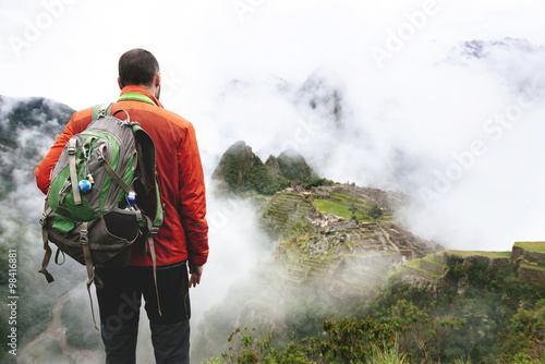 Peru, Machu Picchu region, Traveler looking at Machu Picchu citadel and Huayna mountain photo