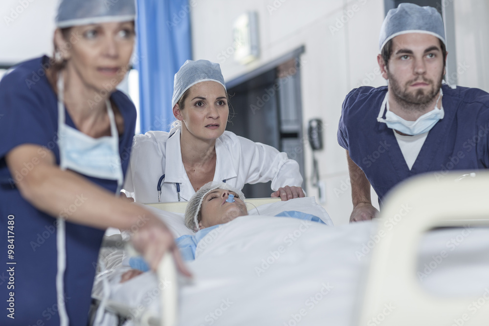 Doctors pushing a bed with patient Doctors pushing a bed with patient