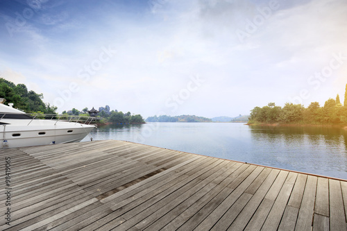 skyline wooden floor and yacht on lake