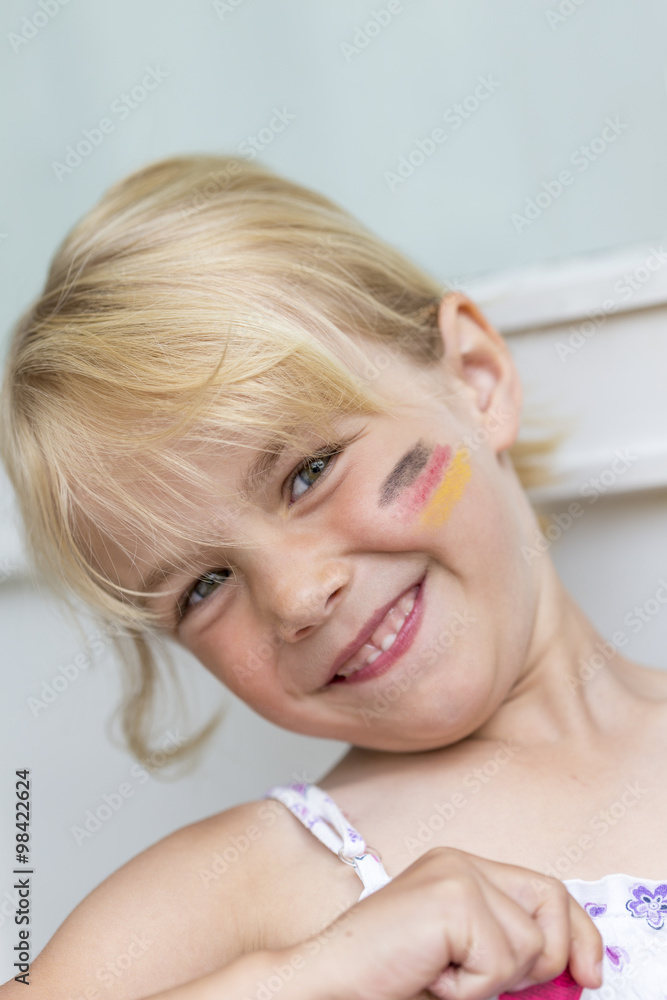 Portrait of blond little girl with German Flag painted on her cheek Portrait of blond little girl with German Flag painted on her cheek