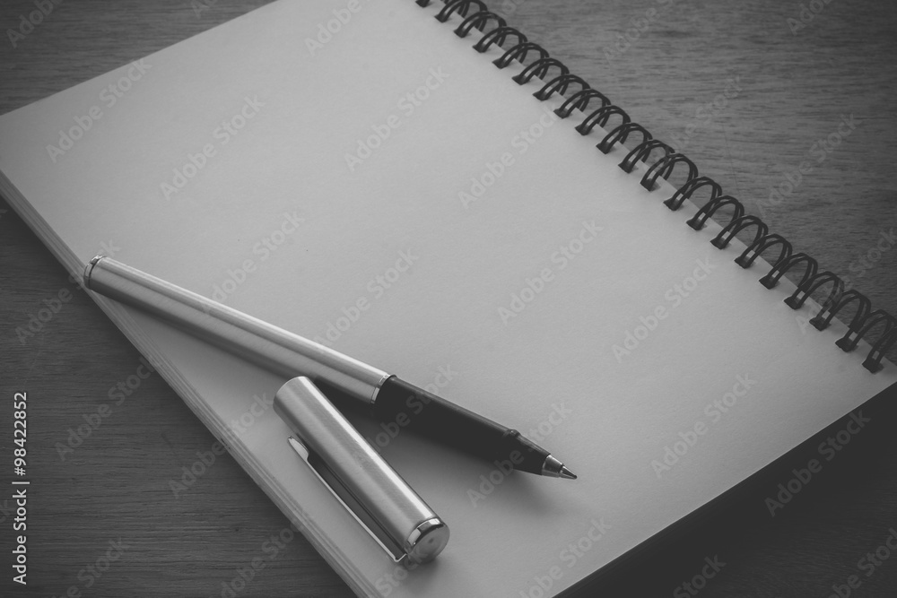 paper notebook and pen on a table with filter effect retro vinta paper notebook and pen on a table with filter effect retro vinta