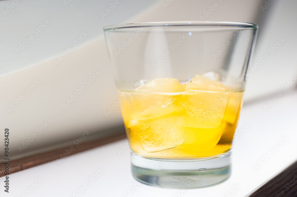 Glass with whisky and ice on the table in the club Glass with whisky and ice on the table in the club