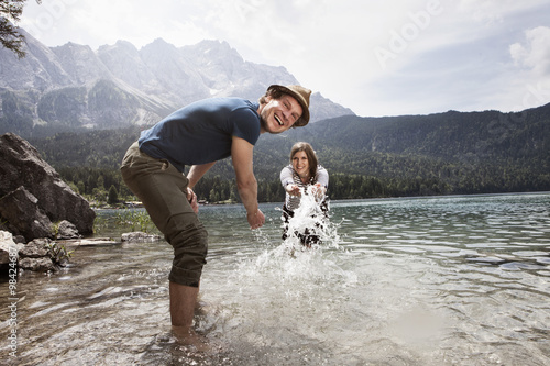 Germany, Bavaria, Eibsee, playful couple splashing in water photo