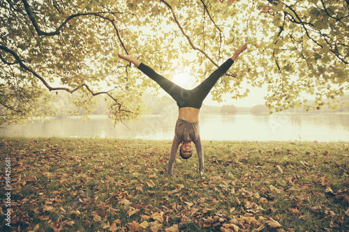 Woman doing a cartwheel in autumn park photo