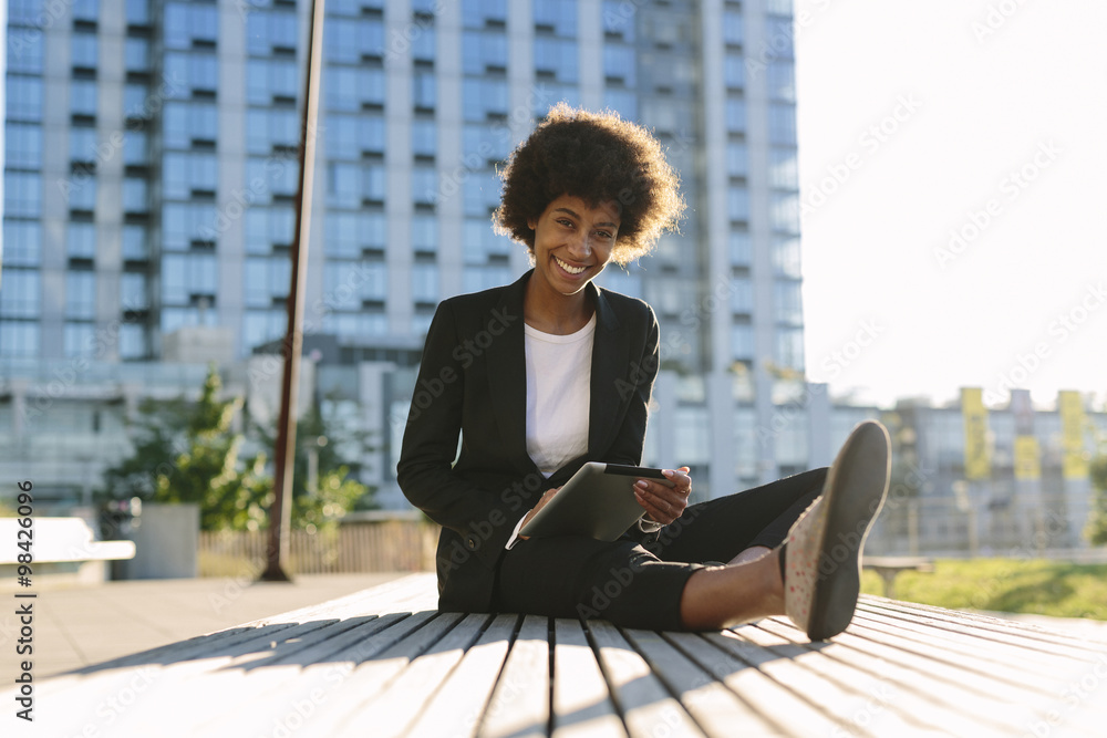 USA, New York City, portrait of businesswoman sitting on a bench with digital tablet USA, New York City, portrait of businesswoman sitting on a bench with digital tablet