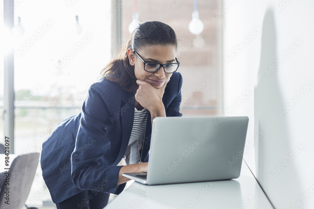 Young woman in office working on laptop Young woman in office working on laptop