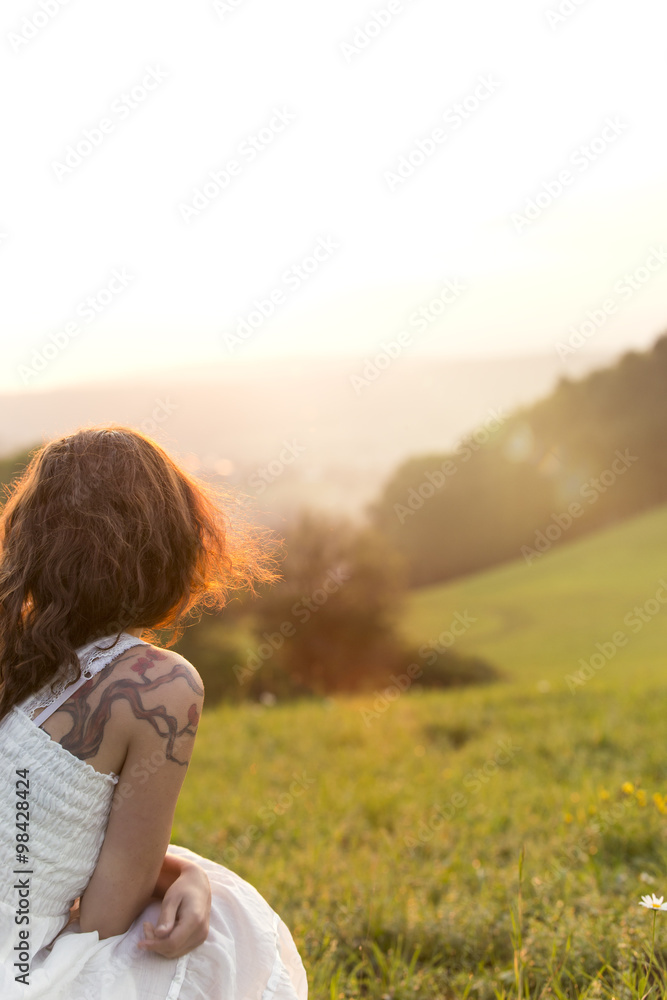 Germany, Baden-Wuerttemberg, Black Forest, back view of woman on Alpine meadow watching sunrise Germany, Baden-Wuerttemberg, Black Forest, back view of woman on Alpine meadow watching sunrise