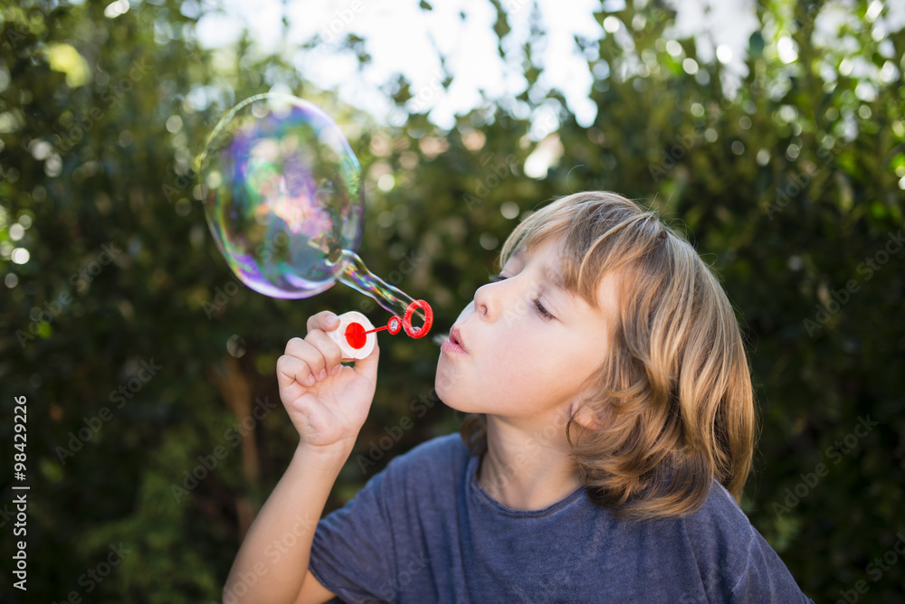 Blond little boy blowing soap bubbles Blond little boy blowing soap bubbles