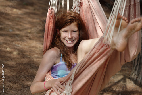 Portrait of smiling girl lying in a hammock