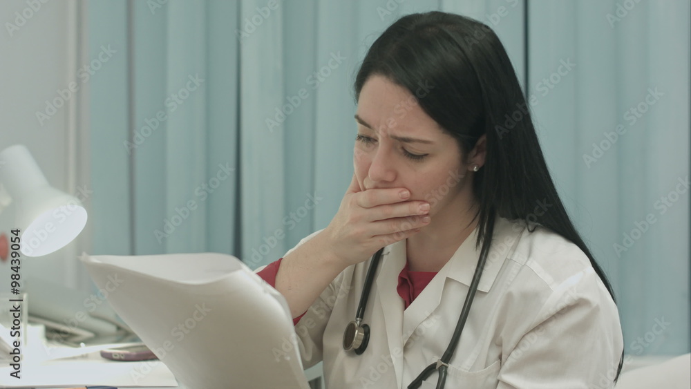 Female medical doctor seriously watching test of results of her patient to diagnose disease Female medical doctor seriously watching test of results of her patient to diagnose disease