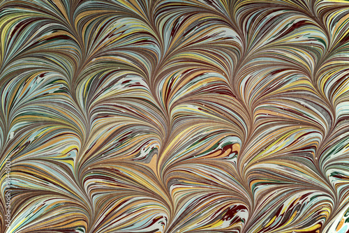 Ebru art. Traditional Turkish Ebru technique. Painting on water, followed by paper prints. Color paint ebru with waves and tile pattern. photo