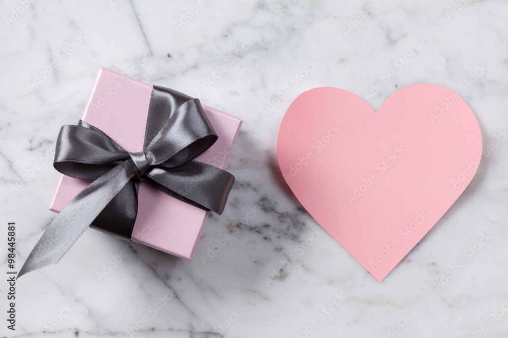 Pink paper heart and gift box on a marble table