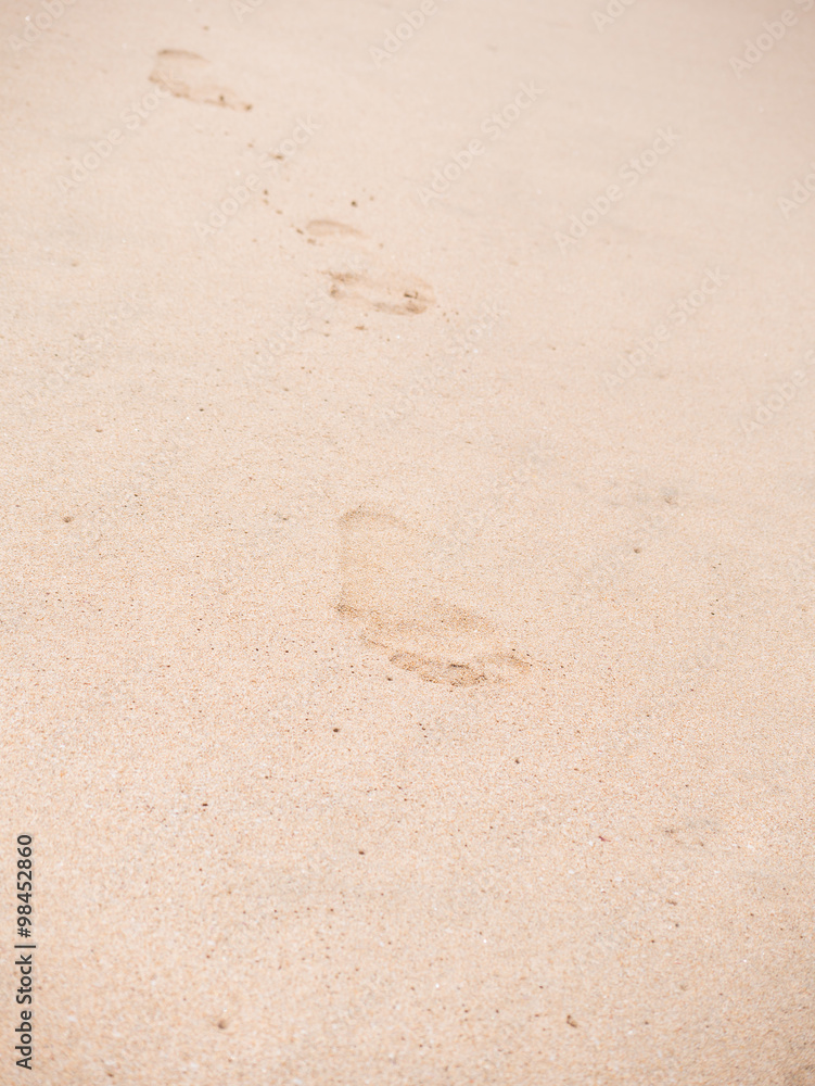 Close up of footprints on the beach sand at the sunset Close up of footprints on the beach sand at the sunset